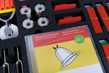 A look into the experiment case for sounds and noises for science lessons; the foam contains the sound CD, the triangular bars, the spools with the tension cord with attached membrane plates.