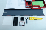 The picture shows a collection of experimental materials, including a gray rail, a flashlight, batteries and various small components. In addition, a manual with instructions on how to conduct experiments is included.
