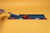 The picture shows a scientific experiment setup consisting of a small platform on a rail equipped with two motors. In the hand someone is holding a measuring device that is probably used for the experiment process.