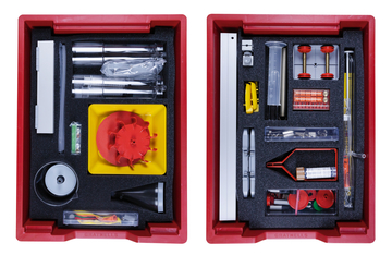 The picture shows two red boxes, each equipped with various experimental materials, including tubes, bottles, measuring devices and turned parts. The materials are neatly arranged in foam pads to ensure stability and protection.