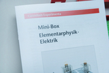 The picture shows part of a catalog for experimental supplies that focuses on the topics of elementary physics and electricity. The mini box shows various components that can be used for physics experiments.