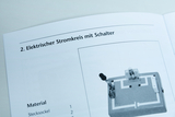 The picture shows instructions for setting up an electrical circuit with a switch. The materials required are listed under the title, including a plug-in base and other components for the experiment.