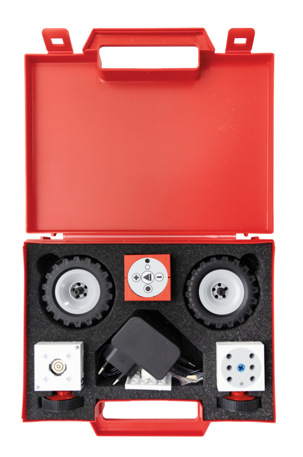 The picture shows a red suitcase filled with various robotics components, including two wheels, a controller and a power supply. All parts are arranged in a black foam insert to protect them and facilitate organization.
