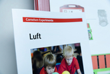 The picture shows a worksheet entitled &quot;Air&quot; from the Cornelsen Experimenta material used in educational settings. Below is a photo of two children playing and experimenting with colorful balls.