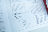 The picture shows a guide for an experiment with suction cups, including material specifications and a sketch. It describes how to use two suction cup hooks and a white plate to study the behavior of the suction cups on different surfaces