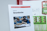 The picture shows a student set on the topic of electrical circuits from the Cornelsen Experimenta range. The cover of the booklet shows two children experimenting, while next to it is an overview of the material it contains.