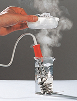 The picture shows a hand holding a container of ice over a beaker of water from which steam is rising. An electrically heated element is immersed in the water, which indicates an experimental setup to test heat conduction or transfer.