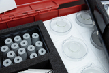 The picture shows an experiment kit with various laboratory parts: grey cylinders and transparent glass containers are neatly arranged in a padded container. These materials are designed for use in education to provide practical