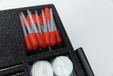 The picture shows a selection of pipettes with red stoppers arranged in a foam insert of a type case. Also visible are two small, wrapped wax candles that could be part of the experimental supplies.