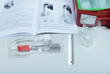 The picture shows an experiment kit with a thermometer, a heater with a coil, a glass jar and instructions. These materials are intended for educational experiments and are intended to help students understand thermodynamics.