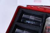 The picture shows a red plastic case with a foam insert in which several transparent tubes are sorted. The accessory seems to be designed for experimental purposes in the educational field.