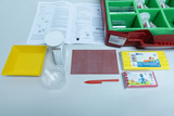 The picture shows a set for experimental purposes in education, consisting of various materials and utensils. These include a measuring cup, a scale, craft materials and instructions on the topic of &quot;floating and sinking&quot;.