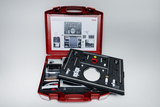 The picture shows a red suitcase with various components for solar thermal energy conversion. The upper half of the suitcase contains instructions, while the lower half is filled with tools and materials for experiments.