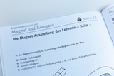 The picture shows a page from an experiment book entitled &quot;Experimenting with magnets and compasses&quot;. It describes a magnet exhibition for teachers that lists different types of magnets such as bar, horseshoe and disc magnets.