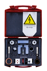 The picture shows a red transport box filled with various experimental materials for electrical science classes. Among them are several devices and accessories that can be used for experiments with high voltage, as well as a warning notice.