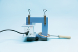 The picture shows an electrical device for conducting experiments, equipped with a copper wire and a control panel. It is designed for educational use to demonstrate physical principles.