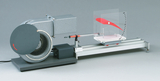 The picture shows an experimental device consisting of a fan and a transparent display panel. It is used to demonstrate air flow and aerodynamic principles in education.