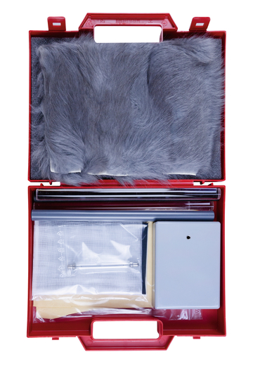 The picture shows a red suitcase containing various experimental materials. These include a piece of grey fur, tubes, a net, a small box and other utensils that can be used for educational purposes in the experimental area.