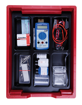 The picture shows a red storage box containing various experimental materials, including a multimeter, alkaline batteries, cables, pliers and chemicals in bottles. The arrangement of the utensils is clear to facilitate use in educational settings.