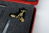 The picture shows a high-quality brass fitting part in a padded case. The case is red and the interior is lined with foam to keep the component safe.