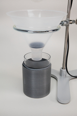 The picture shows a laboratory experimental device consisting of a funnel mounted on a stand and a container underneath. This apparatus is often used in chemical experiments for the filtration or separation of substances.