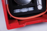 The picture shows a red container with a foam insert that protects various experimental materials. You can see orange tubes, a round can and some gray utensils that can be used for educational purposes in the laboratory.