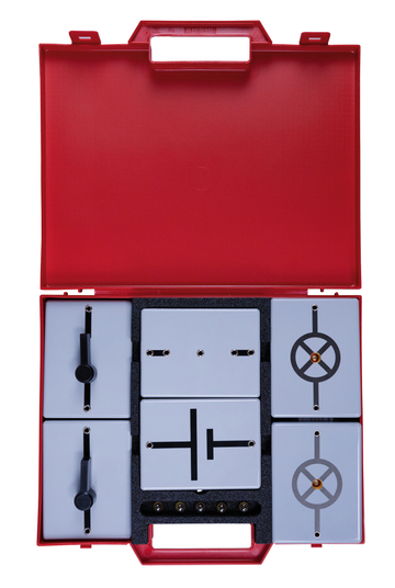 The picture shows a red plastic case containing various measurement elements for experiments. The elements have different graphic representations and are designed to be used in the school experiment environment.