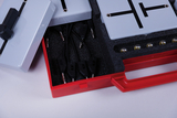 The picture shows a red box filled with experimental materials, including two gray devices and several black cables with plugs. This collection is probably used for physics experiments in education.