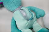 The image shows a colorful, plush stuffed animal with a zipper on the back. The zipper allows the animal to be opened and decorated, making it ideal for experiential learning in educational settings.