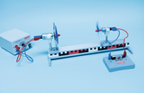 The picture shows an experimental device with an electric motor with a propeller mounted on a rail and a power supply unit. The setup is clearly equipped for educational purposes in the field of physics and offers experimental opportunities to explore movement and electromotorics.