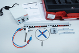The picture shows an experimental set for wind energy, consisting of a power supply, various components such as a propeller and several brackets. In addition, instructions and a red storage box can be seen, which completes the set.