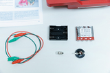 The picture shows experiment materials, including a battery holder, a battery pack, a light bulb, connecting cables with crocodile clips and a lamp holder. These components are suitable for teaching and learning purposes in the field of electrical engineering.