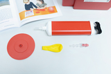 The picture shows various experimental materials, including a red pump, a yellow balloon and a red disk. Additionally, an experiment instruction book is shown, explaining how to use the materials.
