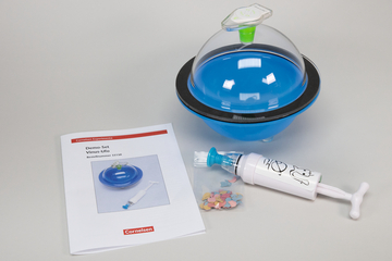 The picture shows a demo set called &quot;Virus UFO&quot; including instructions and accessories. The set includes a blue container, a syringe with a happy face and a bag with colorful, small particles.