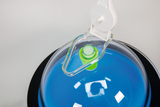 The image shows a transparent dome with a blue liquid content and a green element in the middle. At the top of the dome there is a white cap, which is probably for access or ventilation.