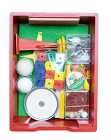 The picture shows a red box with various experimental materials for educational purposes. It contains balls, building blocks, rubber bands and other utensils that can be used for physical or creative experiments.