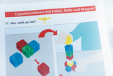 The picture shows instructions for experimenting with a lever, pulley and magnet. Two images illustrate how different colored cubes can be stacked while a person&#39;s hand picks up a yellow figure.