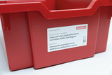 The picture shows a red experiment box with the title &quot;Anja and Leon experiment with levers, pulleys and magnets&quot;. The label contains information for a kindergarten experiment series in German and English.