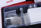 The picture shows a set of transparent laboratory vessels, including beakers and an Erlenmeyer flask, in a protective case with black foam. The set is intended for experimental needs in the German educational system and comes from the Cornelsen brand.