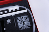The picture shows parts of an experiment kit stored in a red case. You can see various grey components, a flexible tube and a control knob, which are probably intended for scientific experiments in the educational sector.