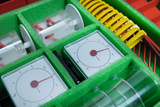 The image shows a selection of experimental equipment, including measuring instruments and transparent containers, neatly arranged in a green foam insert. The equipment is ideal for science education and experiments in schools.