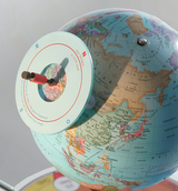 The image shows a detailed globe with an adjustable, circular marker element that indicates the cardinal directions. It serves as a teaching tool for geographical orientation and for visualizing continents and countries.