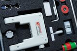 The picture shows a set of experimental supplies in a foam insert, containing various devices and components. The focus is on a white device with the inscription &quot;Smart Q&quot;, surrounded by other parts such as magnets and holders.
