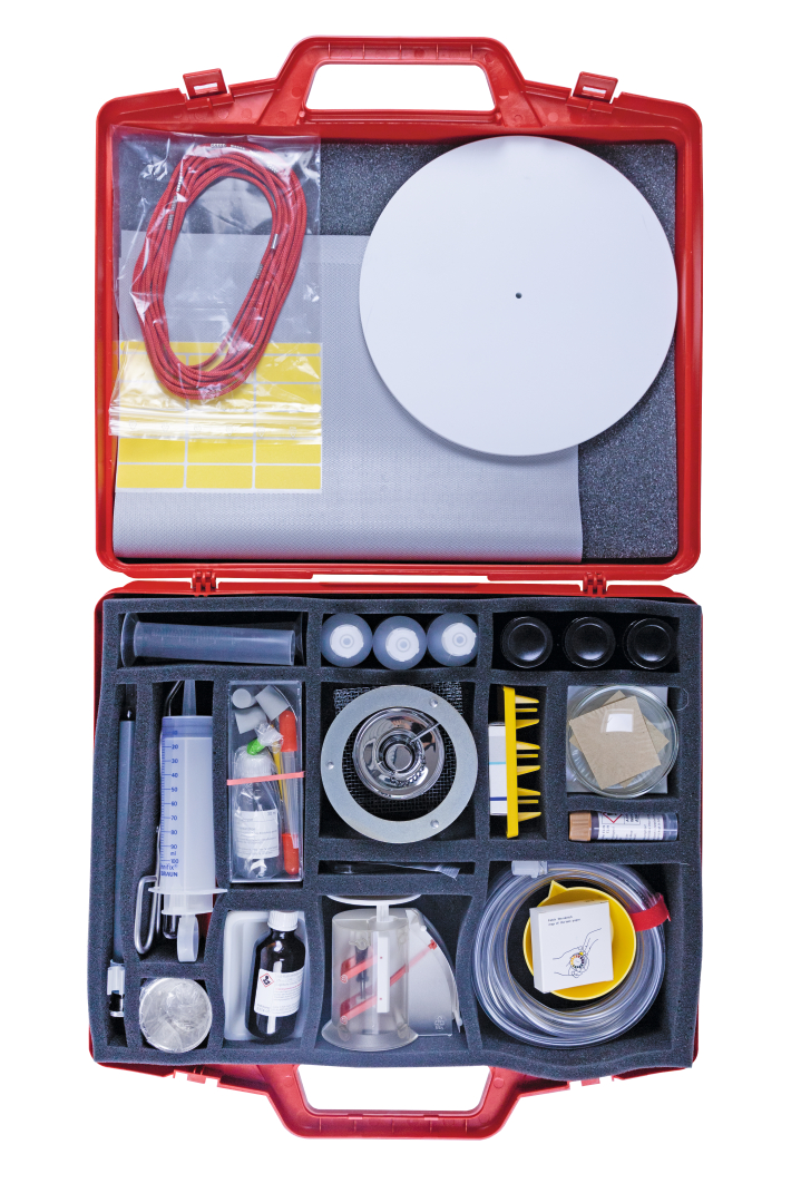 The picture shows a red suitcase containing various experimental materials for teaching. Inside are various containers, tools and materials that can be used for scientific experiments.