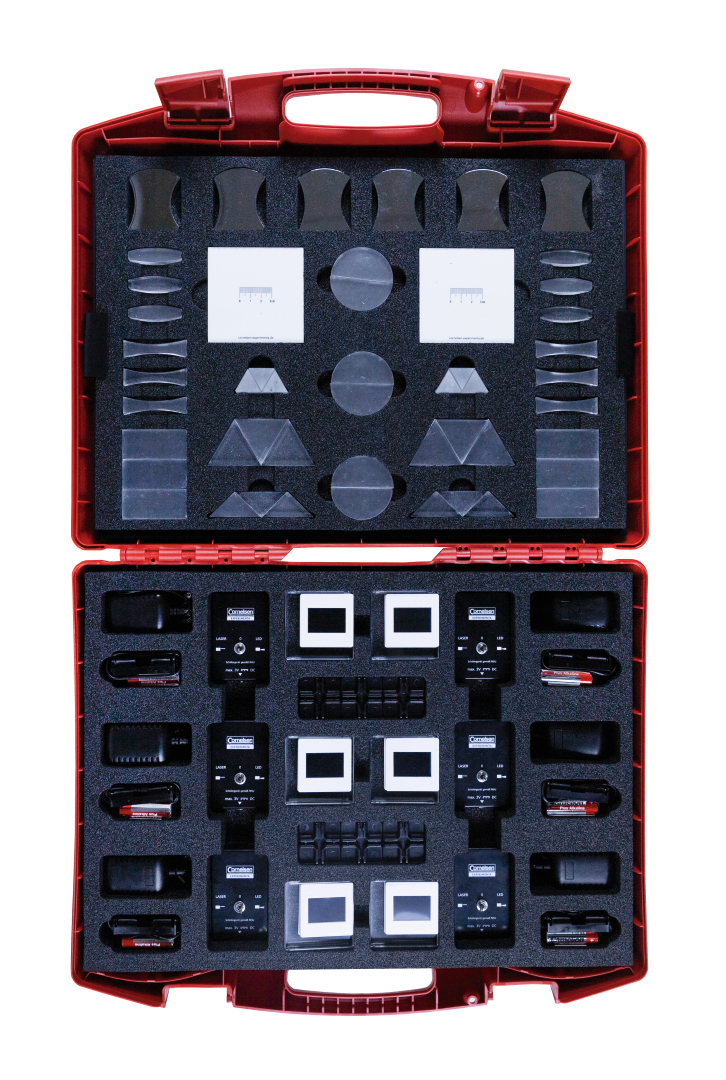 The picture shows a red case set containing various optical elements and accessories for experiments in education. The parts are neatly arranged in foam, allowing for easy access and transport.