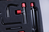 The image shows a collection of glass containers and tubes arranged in a foam pad. The utensils have red-colored caps and are designed for chemistry experiments in an educational context.
