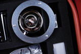 The picture shows an experimental device housed in a protective foam box. In the center is a metal holder with a sample, surrounded by various other components such as containers and accessories.
