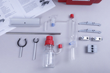 The image shows a selection of laboratory equipment, including glass containers, tubes and holders that can be used for various educational experiments. Also visible are instructions and a red container with additional materials.