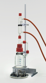 The picture shows a chemical experiment device with a glass bottle indicating a volume of 200 ml, as well as several connecting tubes and a heater underneath. The whole setup is mounted on a sturdy tripod, ideal for educational purposes in the laboratory.