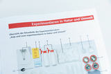 The picture shows an overview of the individual parts of an educational experiment kit aimed at experimenting in nature and the environment. Various materials and equipment are numbered and listed to facilitate use in the classroom.